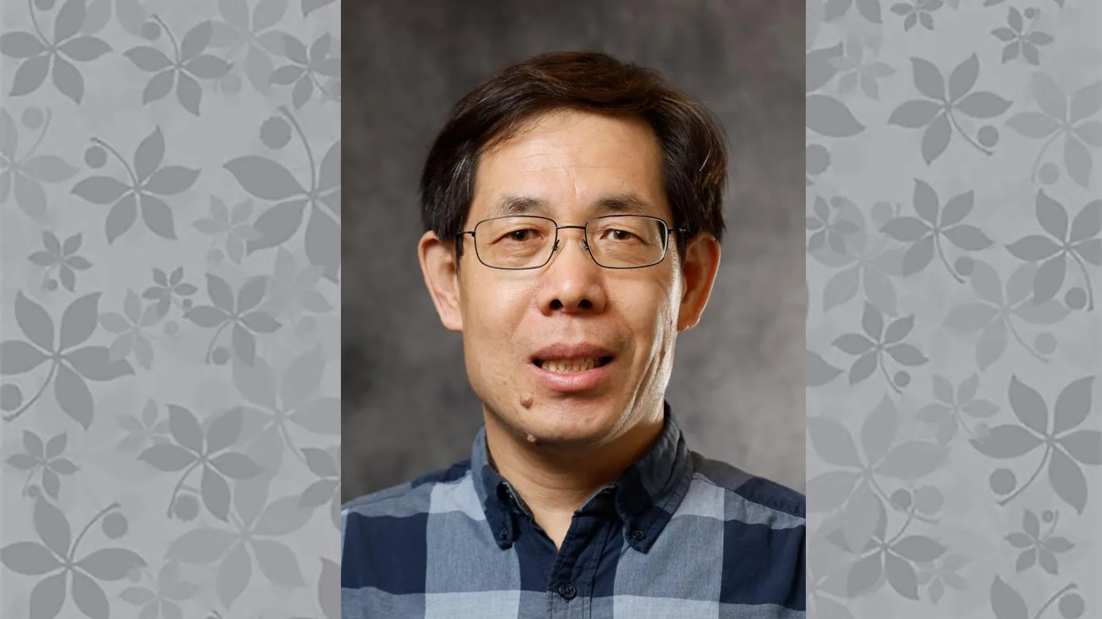 Headshot of Jian-Qiu Wu on a background of buckeye leaves