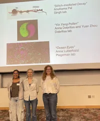 Winners of the art contest smiling in front of a slide with the art